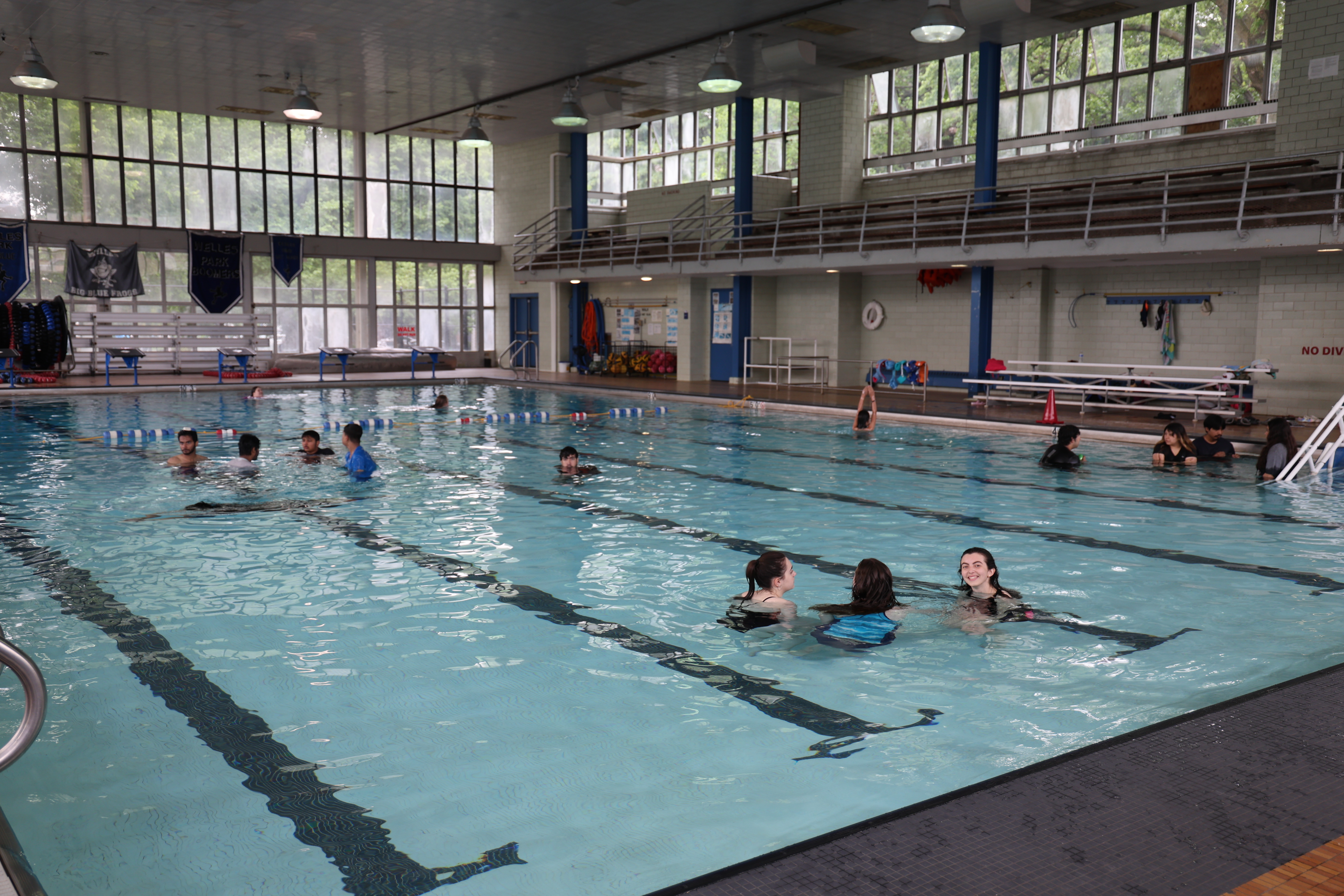 Indoor swimming pool with several people enjoying the water.